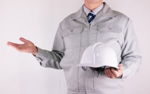 ヘルメットを持つ作業服の男性